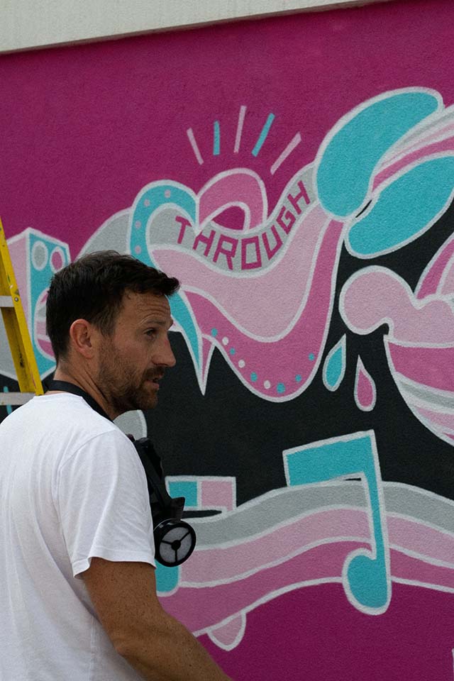grafitero profesional delante de un mural